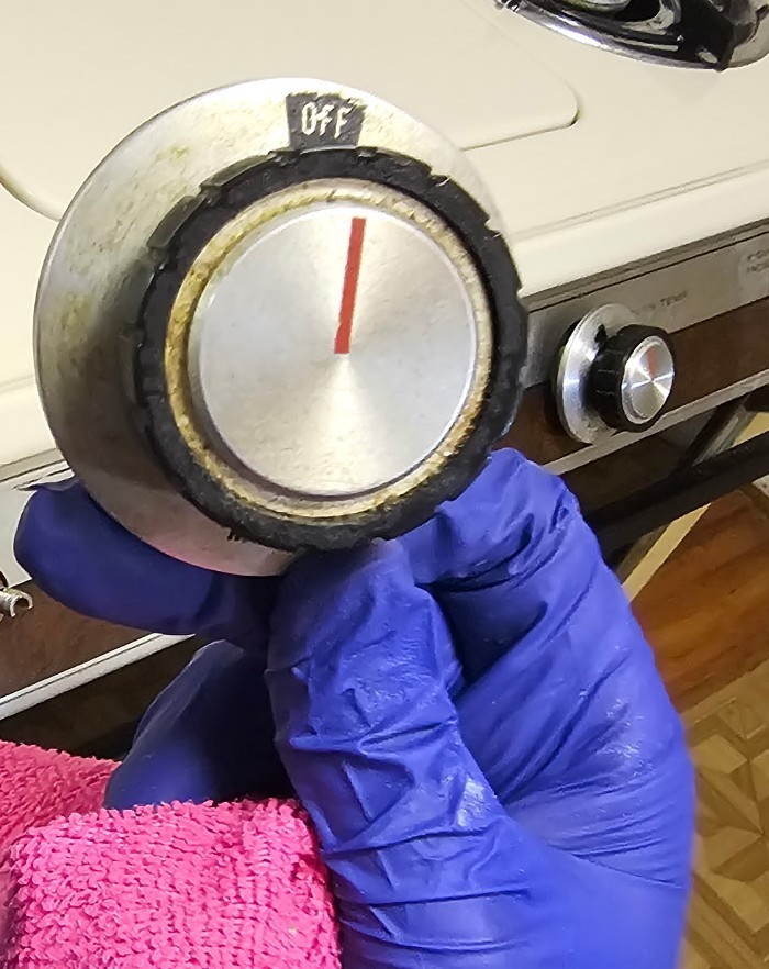 Greasy stove control knob with baked-on food grime before deep cleaning