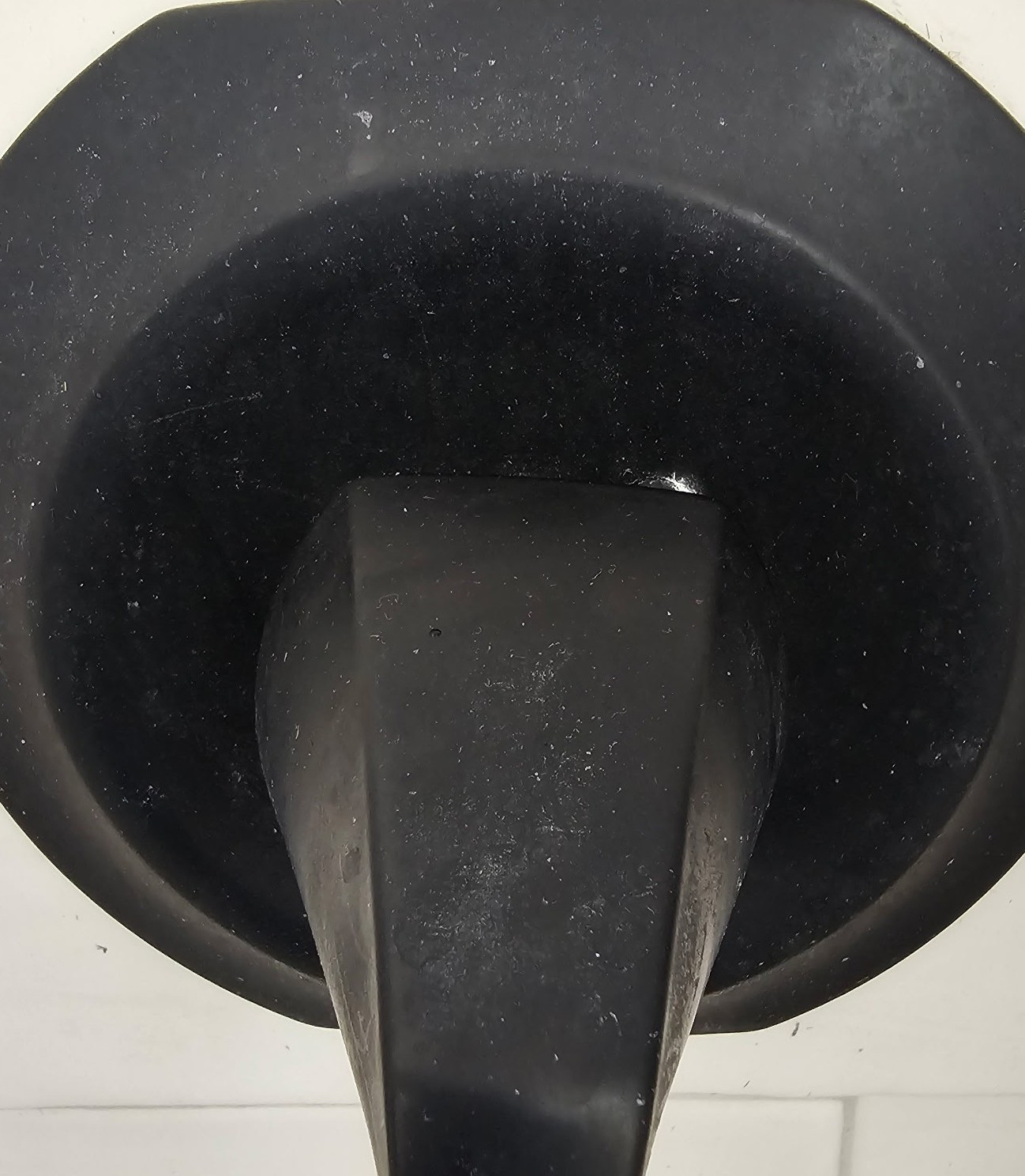Matte black shower handle covered in hard water scale and soap scum residue before professional cleaning